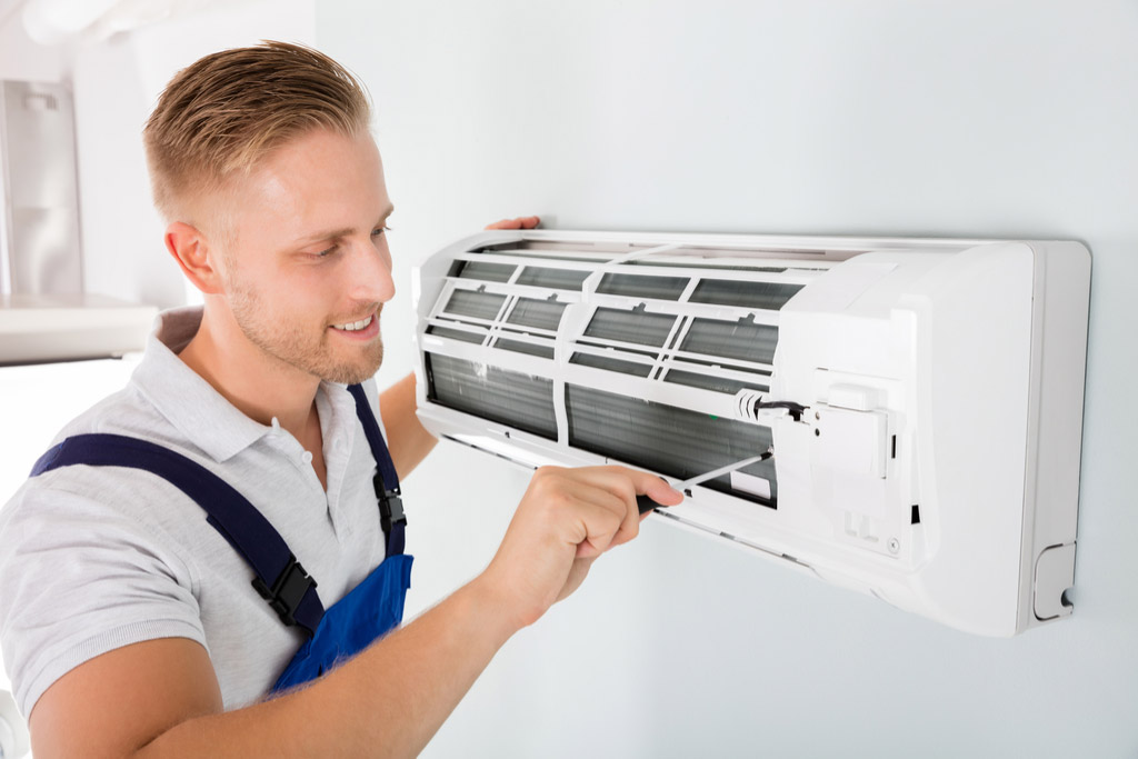 HVAC technician cleaning and repairing a ductless mini split AC in Marana, AZ