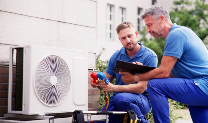 HVAC technicians reviewing an outdoor air conditioning unit in Marana, AZ