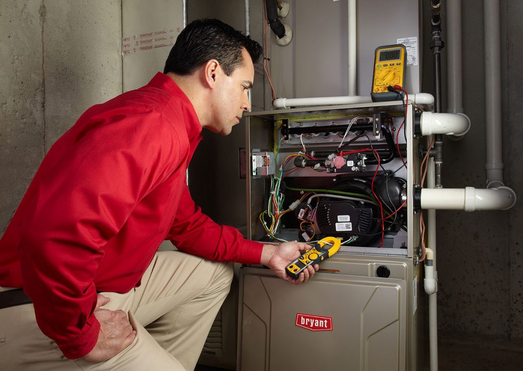 Heating and air conditioning technician servicing an indoor furnace in Marana, AZ