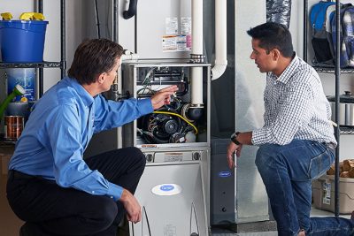 HVAC technician explaining furnace repair and maintenance to a homeowner in Marana, AZ