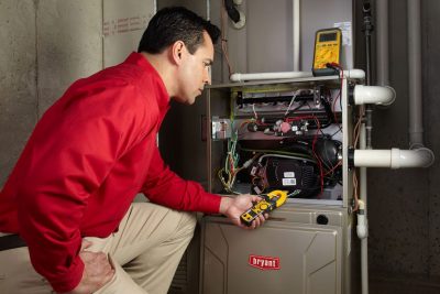 Heating and air conditioning technician servicing an indoor furnace in Marana, AZ